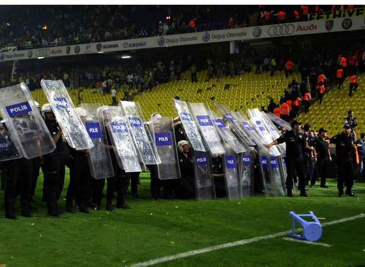 dagligdag. Tyrkisk politi kommer ofte på overarbejde i forbindelse med fodboldkampe. Her beskytter de sig mod en regn af skyts sendt af sted fra Fenerbahce-tilhængernes afsnit på stadion i Istanbul. 