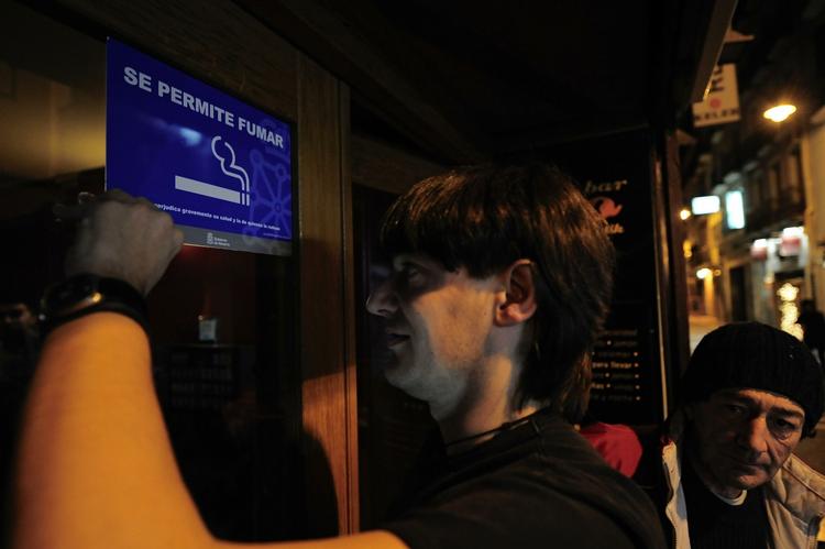 Udskiftning. Robert, der ejer en bar i Pamplona, fjerner et rygning tilladt-skilt, fordi rygning fra i dag er forbudt på alle offentlige steder i Spanien. 