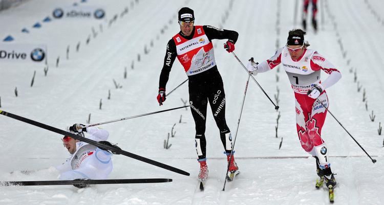 snævert. Vinder Emil Jönsson fra Sverige er faldet efter passge af målstregen, mens Devon Kershaw fra Canada (th) misser muligheden for at komme i front i Tour de Ski. 