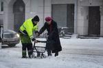Budgetkaos. Hovedstaden en typisk dag i december. En ældre dame hjælpes over en snedækket Valby Langgade. 