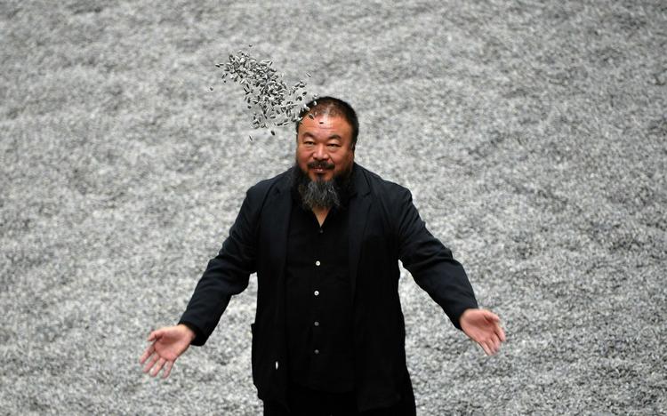 »Jeg er under husarrest, fordi de vil forhindre mig i at rejse til Shanghai«, fortæller Ai Weiwei over telefonen fra sin lejlighed i Beijing. Her er han fotograferet i på Tate Modern i London, hvor udstiller i tusindvis af håndmalede solsikkekerner. 