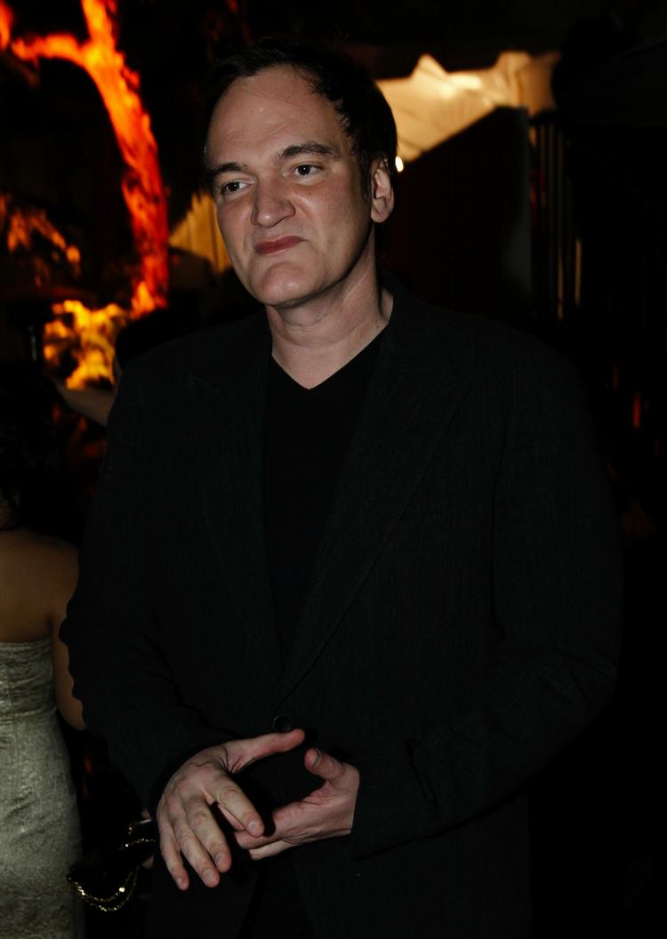 Klassens evige frække dreng Quentin Tarantino på vej til efterfest med ild i baggrunden. 