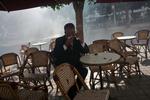 Dagligliv. En ældre tuneser prøver at trække vejret for tåregas gennem et lommetørklæde ved et cafebord på Avenue Bourguiba, hovedgaden i det centrale Tunis. 