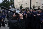 Demonstration. En tilhænger af oppositionen går til angreb på politifolk under dagens tumult i Tirana. 