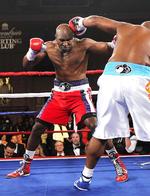 Ramt. Evander Holyfield får en på hovedet af Sherman 'The Tank' Williams i aftenens kamp. 