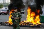OPTØJER. Libanesisk soldat foran brændende dæk, antændt af demonstranter i Beirut  protest mod den nye ministerpræsident. 