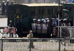 En ældre egyptisk mand passerer egyptiske sikkerhedsstyrker under sammenstødene mellem demonstranter og politi efter dagens fredagsbøn. 