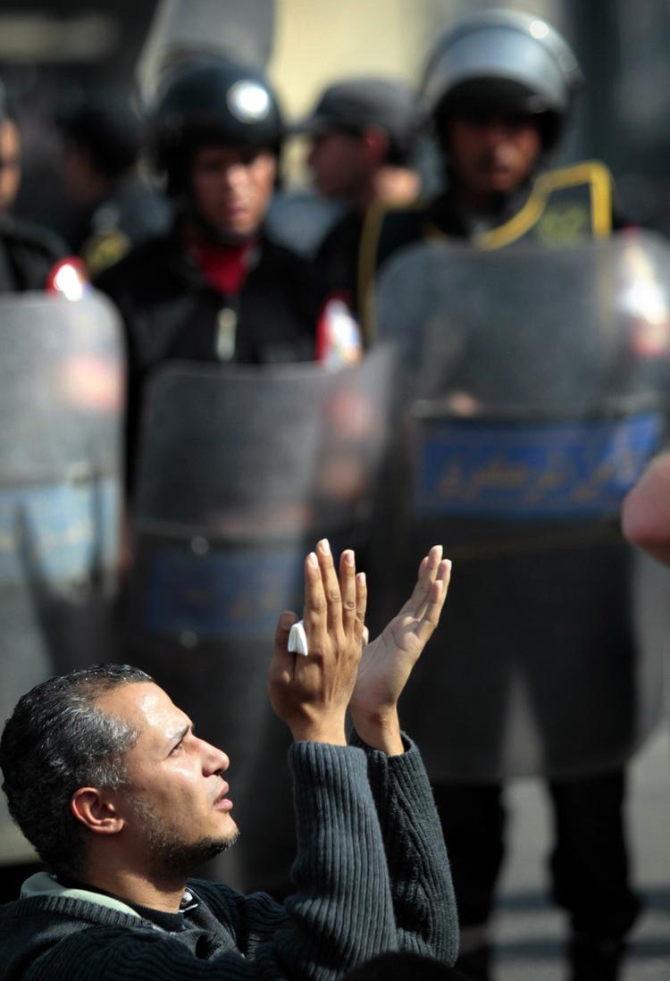 En demonstrant beder fredagsbøn foran de egyptiske sikkerhedsstyrker i hovedstaden Kairo. 