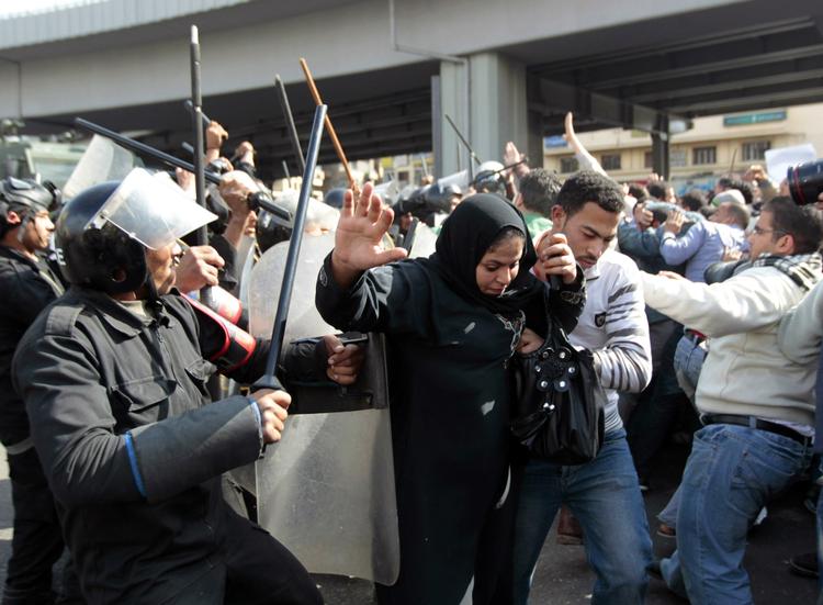 Egyptisk kvinde flygter fra sammenstød mellem egyptiske styrker og demonstranter i hovedstaden Kairo efter dagens fredagsbøn. 