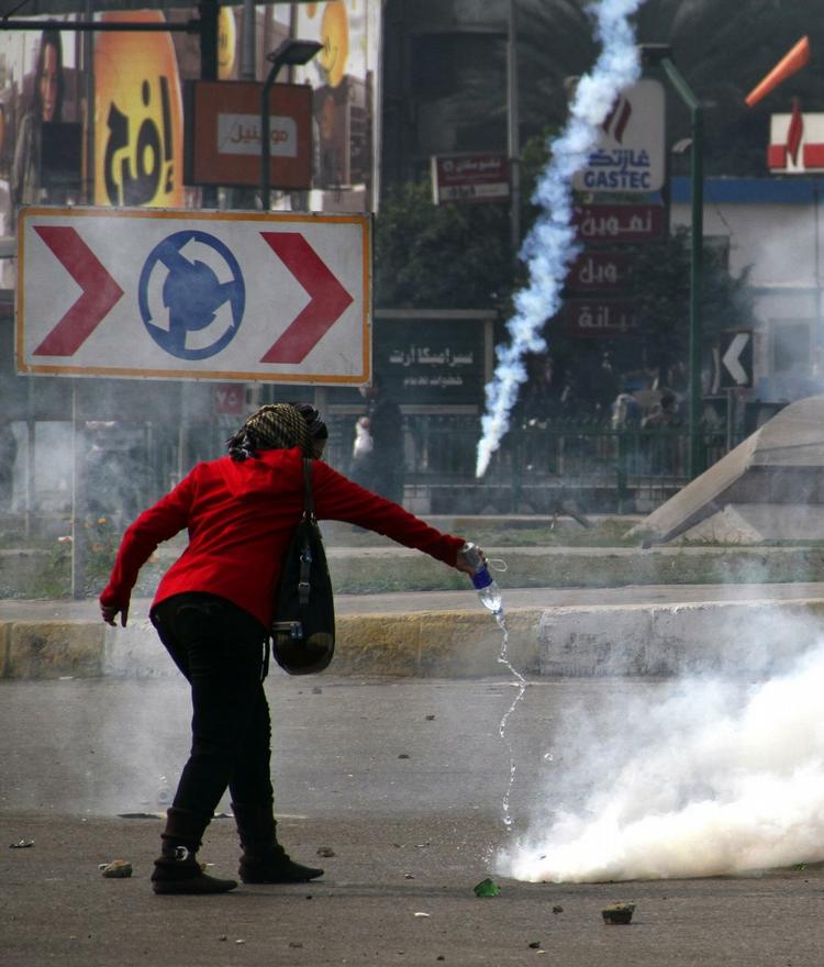 En egyptisk demonstrant hælder vand på tåregassen. 