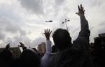 Sammenhold. Demonstranter i Kairo vinker mod en militærhelikopter, der sammen med flere fly viste sig over byen umiddelbart inden aftenens udgangsforbud trådte i kraft. 