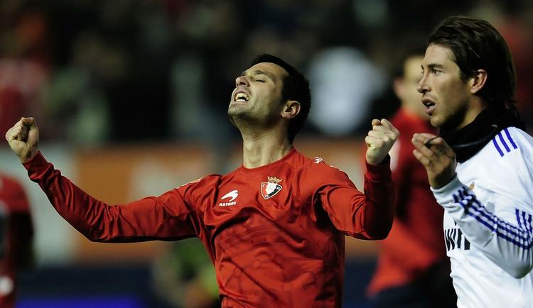 Osasuna's Miguel Flano (tv) jubler efter sejren over Sergio Ramos (th) og Real Madrid. 
