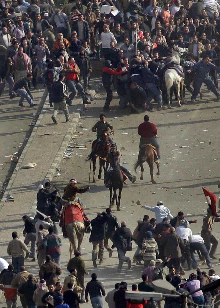 Overtag. Mænd med køller slog mod demonstranterne fra kamelryg. 