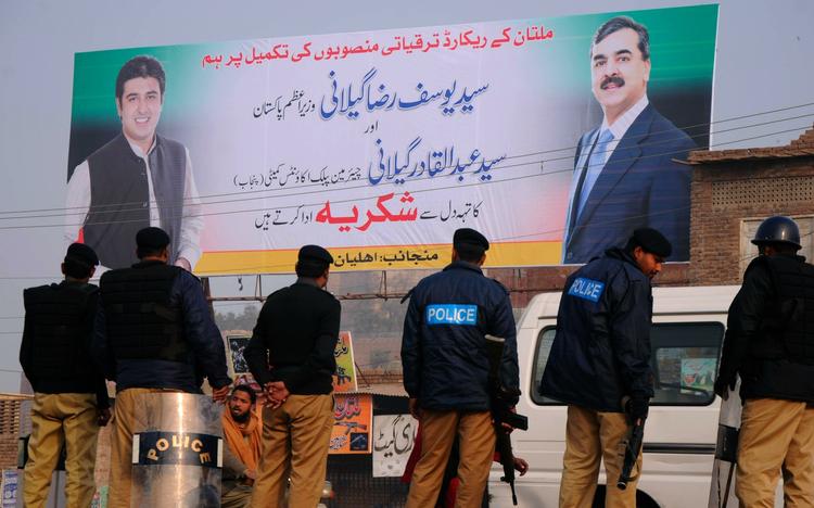 Magthaver. Pakistans premierminister, Yousuf Raza Gilani, poserer til højre på den store plakat i byen Multan. Herren til venstre er hans søn, Abdul Qadir. 
