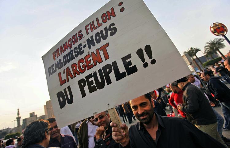 SKANDALE. "Francois Fillon, giv os folkets penge tilbage!!", står der på en degyptisk demonstrants skilt, efter afsløringen af, at den franske premierminister har været på solferie i Egypten med sin familie med alt betalt af den egyptiske regering. 