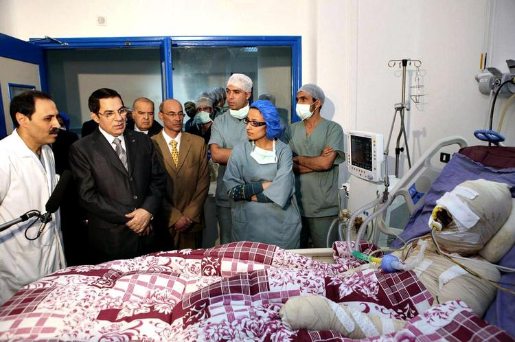 Martyr. Tunesiens præsident, Ben Ali, nummer to fra venstre, besøger Mohamed Bouazizi på hospitalet. Bouazizi satte i december ild til sig selv i en protestaktion, der udløste opstanden mod Ben Ali. Bouazizi døde af sine skader 4. januar. 