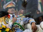 I dette arkivfoto fra 2009 sidder Libyens diktator Gaddafi bag en skærm af skudsikkert glas til en militærparade. 