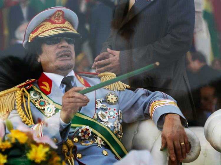 I dette arkivfoto fra 2009 sidder Libyens diktator Gaddafi bag en skærm af skudsikkert glas til en militærparade. 