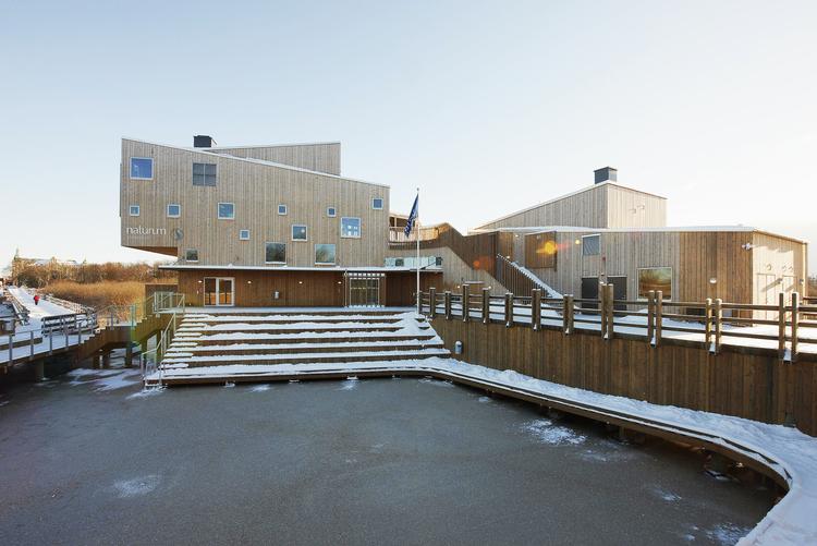 Midt i naturen - men kun 500 meter fra Kristianstads centrum - svæver oplysningscentret over vådområdet. Iklædt fyrretræslameller, der får det til at falde ind i  området. Indenfor genkender man arkitekten Fredrik Pettersons glæde ved spiralen og lamellerne, som også kendetegner hans Søbad i Kastrup. Foto: Åke E:son Lindman 