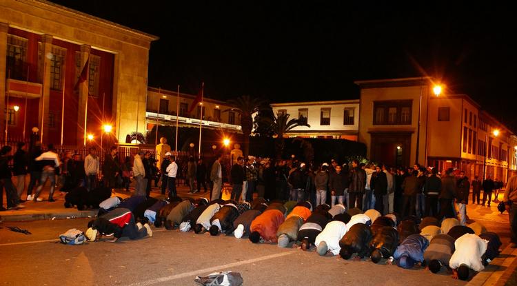 Bedepause. En gruppe unge demonstranter tager en bedepause under en sit-in demonstration foran Marokkos parlamentsbygning i  hovedstaden Rabat. 