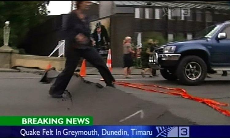 Fodgænger skræver over brudlinje på gade i Greymouth på Sydøens vestkyst, hvor jordskælvet også har kunnet mærkes. 