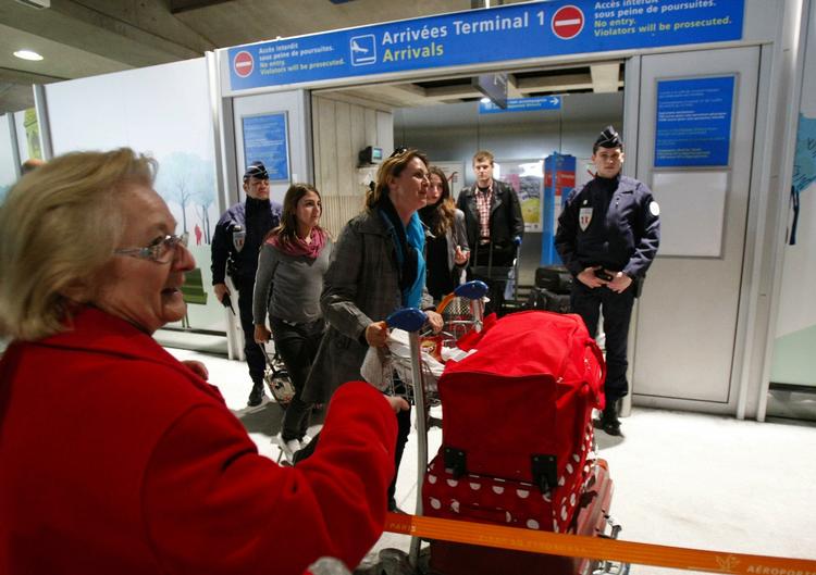 evakuering. En anonym, ældre kvinde smiler, da hendes datter ankommer fra Libyen til Roissy lufthavnen i Paris. 