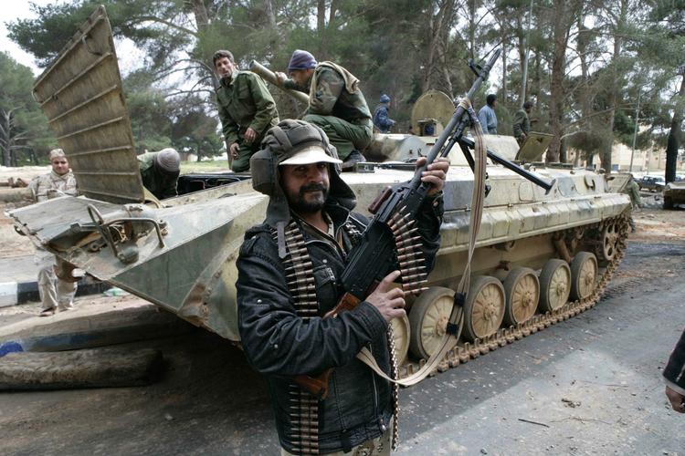 Sejrsrus. Endelig er der begyndt at slippe billeder ud af Libyen. På dette billede, sendt hjem af det kinesiske nyhedsbureau Xinhua, posserer en oprører foran en tilfangetaget tank i den østlige by Albayda. 