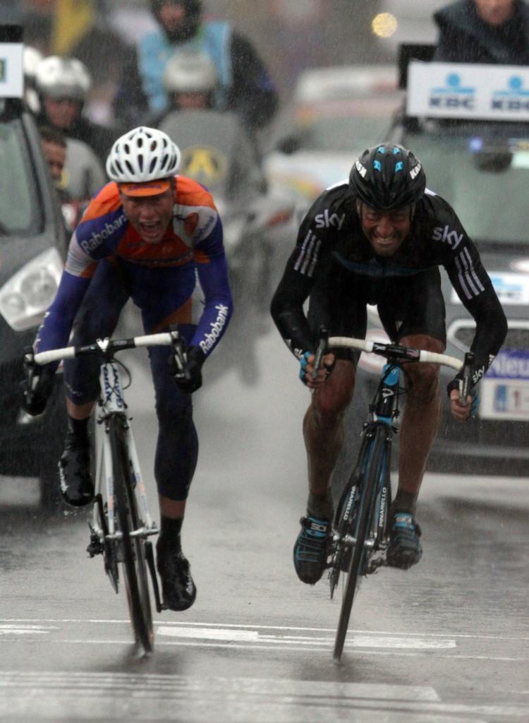møgbeskidt. Vind og vejr satte sit præg på løberne, inden Sebastian Langeveld (tv) kunne vinde spurten over Juan Antonio Flecha i 'Omloop Het Nieuwsblad'. 