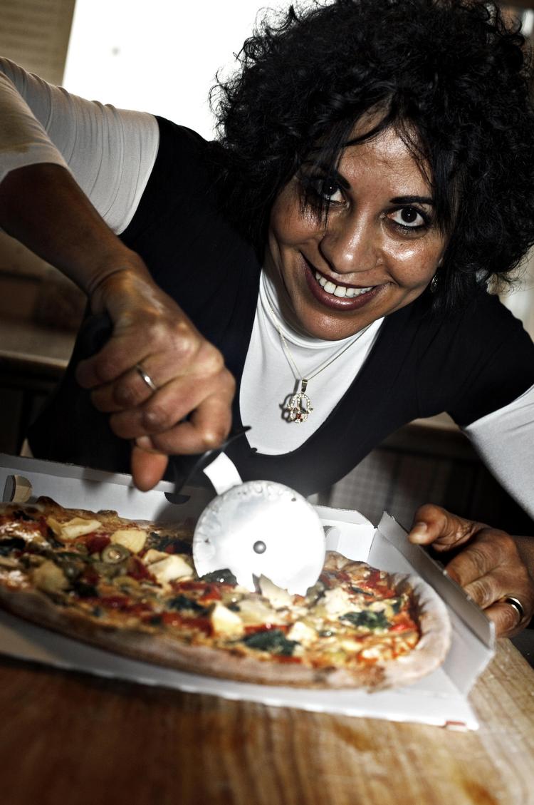 supersnit. Fatima Maliane fra  Sølvstjernen Pizzeria på Amager viser, hvordan pizzahjulet fra Oxo med lethed deler en pizza nummer 5 fra menukortet - en Vegetar med tomat, ost, rød peber, champignon, artiskok, spinat og oliven. 