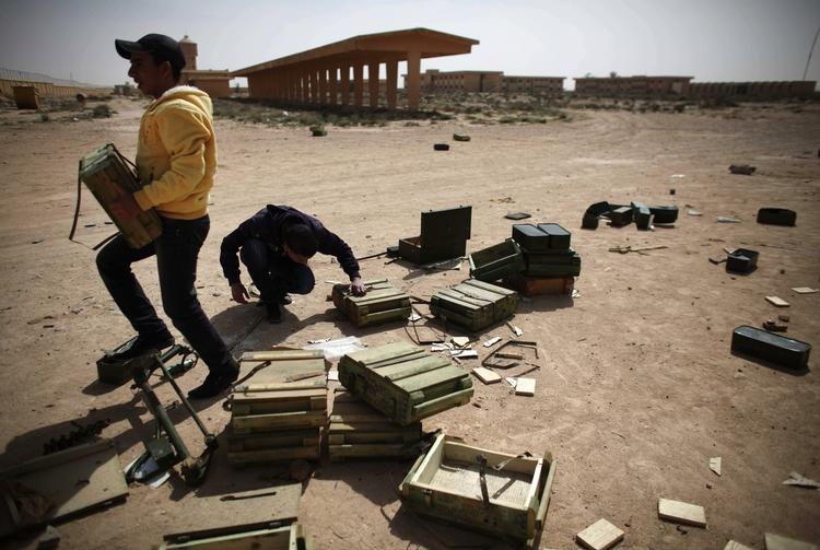 Angrebet. Ajdabiya i går. Libyske oprørere samler ammunition inde fra en militær base i byen, som lige nu er under heftigt luftbombardemant fra regeringsstyrkerne. 
