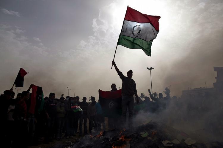 En demonstrant står på toppen af bunke brændende politiske bøger i en Libyske by Bangazi. 