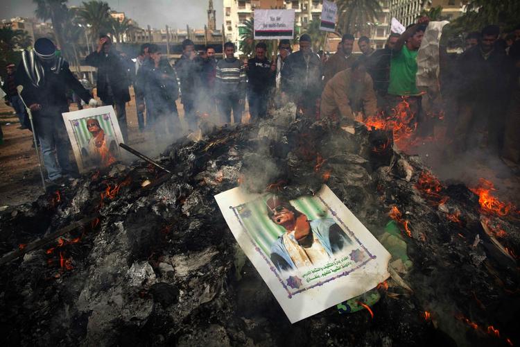 Demonstranter brænder plakater af Moammer Gaddafi ved en demonstrantion i Bengazi. 