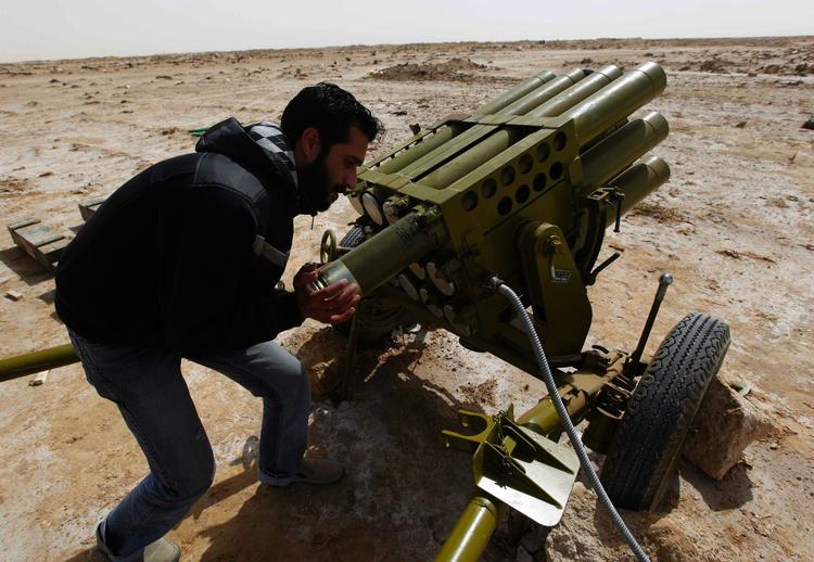 En oprørsoldat lader en raketaffyringsrampe med ny ammunition udenfor byen Brega i det østlige Libyen. 