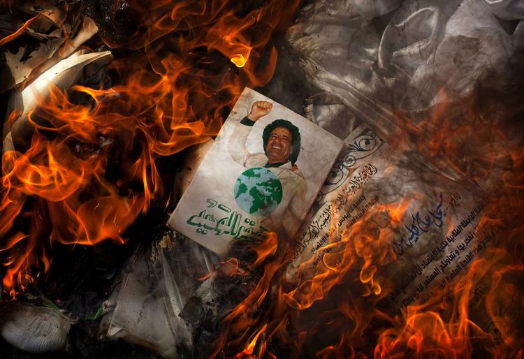 En politisk bog med et billede af Moammar Gaddafi på omslaget afbrændes i Bengazi. 
