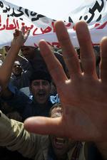 Protester. Egyptiske demonstranter kommer med tilråb mens en politibil transporterer tidligere minister Habib-el-Adly, der blandt andet er anklaget for hvidvask af penge, til retten i Kairo. 