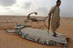 KAMPPILOTER. Oprører ved vraget af nedskudt libysk kampfly, hvis pilot ifølge Gaddafi-modstanderne tilsyneladende kom fra Syrien. 