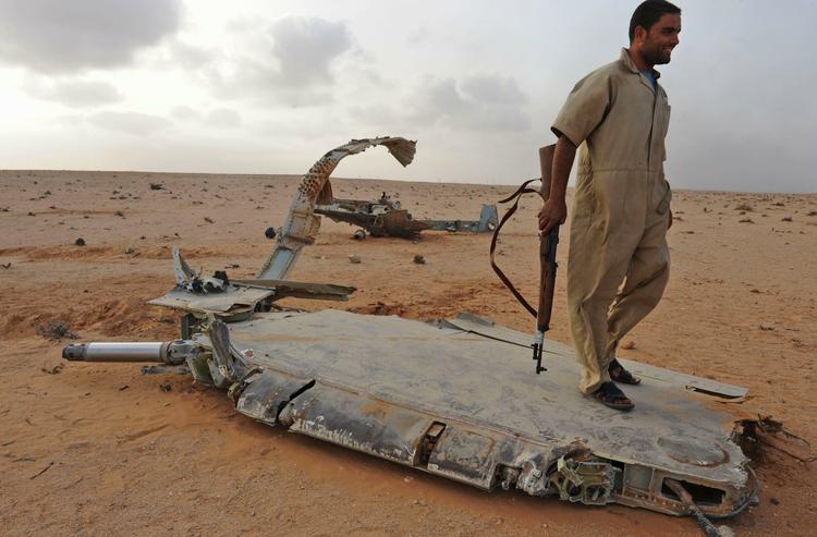 KAMPPILOTER. Oprører ved vraget af nedskudt libysk kampfly, hvis pilot ifølge Gaddafi-modstanderne tilsyneladende kom fra Syrien. 