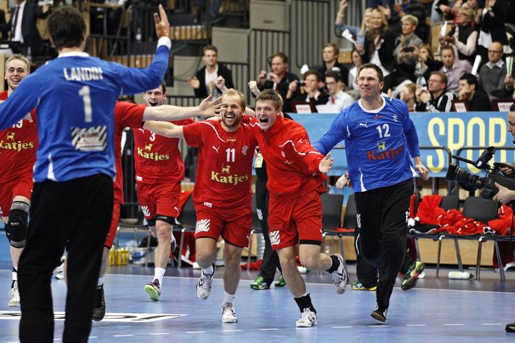 visum-kvaler. Jublende Anders Eggert , Lasse Svan Hansen og Søren Rasmussen løber på banen efter Danmarks sejr mod Spanien ved VM i Sverige. De tre spillere er strandet i København på grund af en fejlagtig visumbehandling i Rusland. 