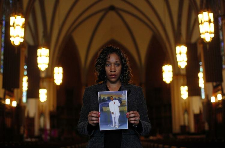 Uenig. Pam Bosley i St. Sabina Catholic Church i går. Hun bærer et billede af sin søn, Terrel, der blev dræbt af en ukendt gerningsmand i 2006. Den der dræbte ham, fortjener ikke at leve, siger hun. 