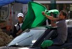 Gaddafi-land. Her holder støtter af Gaddafi et grønt flag op, da de møder et hold udenlandske journalister i byen Janzour, der ligger 12 kilometer uden for hovedstaden. 