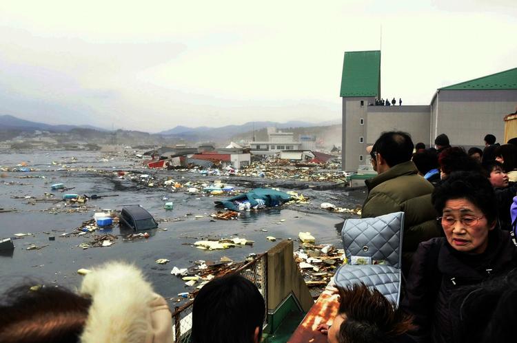 Sikkerhedsafstand. Beboerne i byen Kesennuma  i det nordlige Japan betragter følgerne af tsunamien på sikker afstand. 