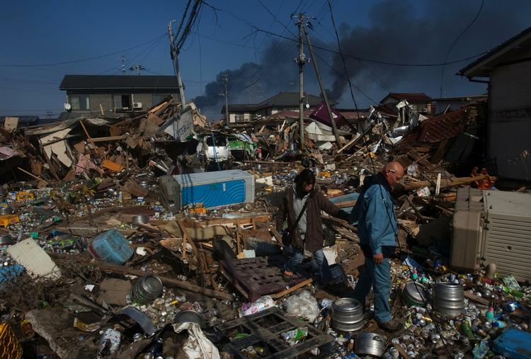 ruiner. Et japansk par går gennem ruinerne af deres nabolag i Sendai i det nordøstlige Japan. For to dage siden hærgede jordskælv og tsunami området. 