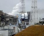 Hærget. Fukushima Dai-ichi atomkraftværkets reaktor fire, hvor der udbrød brand i går. I baggrunden ses den ligeledes ramte reaktor tre. 