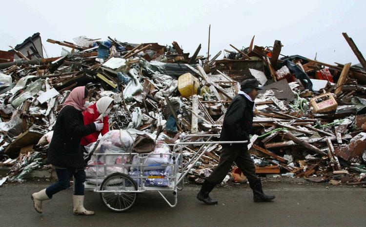 OVERLEVENDE. Familie trækker ejendele gennem Yamada i det nordlige Japan. 