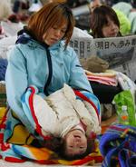 Mor og barn hviler sig i et center for evakuerede i Ishinomaki. 