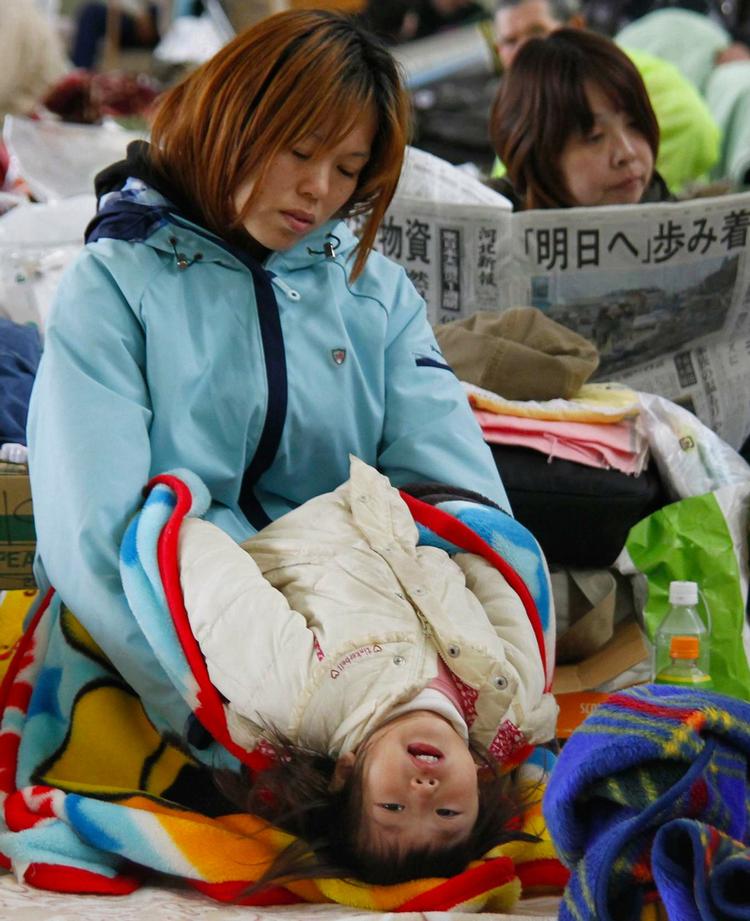 Mor og barn hviler sig i et center for evakuerede i Ishinomaki. 