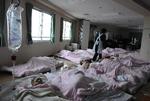 Patienter ligger på gulvet på et overfyldt hospital i Ishinomaki. 