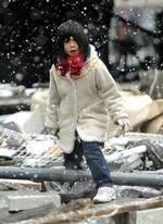 En pige søger efter egendele i ruinerne af sit hus i  Kamaishi. 