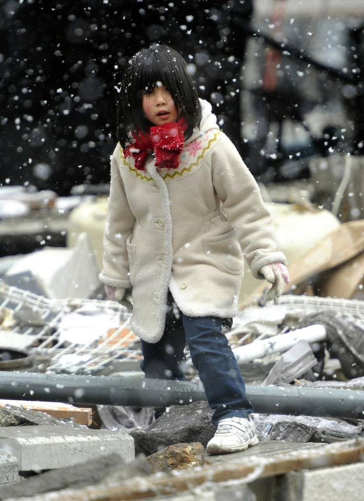 En pige søger efter egendele i ruinerne af sit hus i  Kamaishi. 