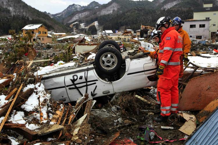 Nogle af de 220 redningsfolk fra USA og England søger efter ofre i ruinerne af byen Kamaishi, 